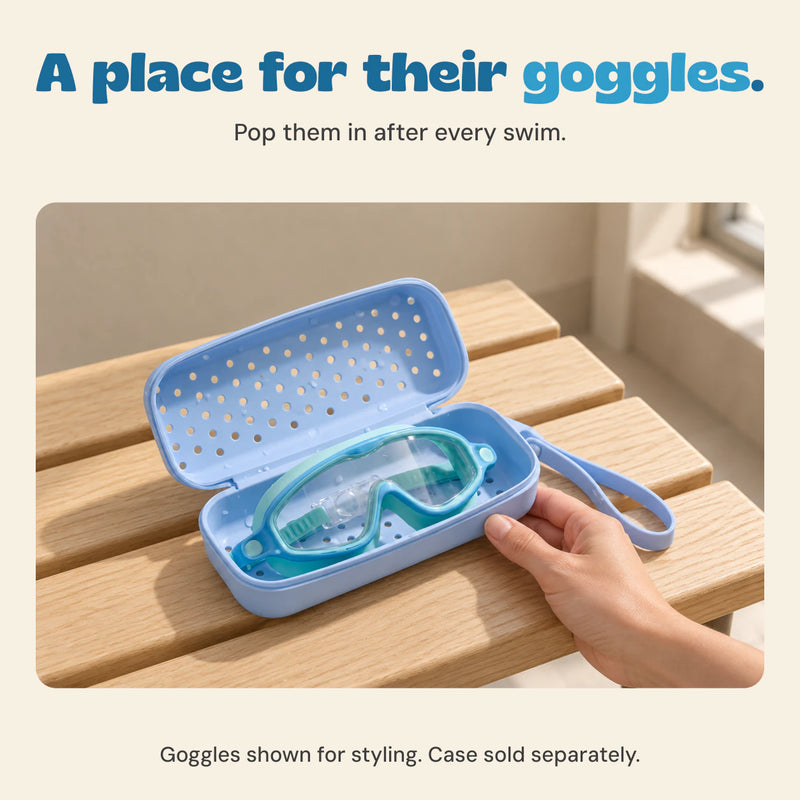 Adult hand holding the open blue goggle case with teal swim goggles inside. Goggles shown for styling, case sold separately.