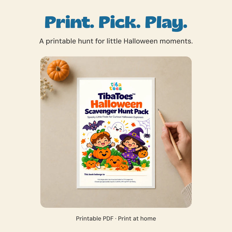Adult hand holding a pencil beside a printed example of the original Halloween Scavenger Hunt Pack cover on a quiet table.
