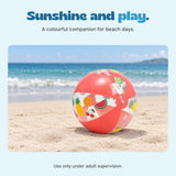The Fruity Splash beach ball rests on pale sand beside the sea.