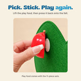 Close-up of a hand lifting the toy apple from the felt attachment patch.