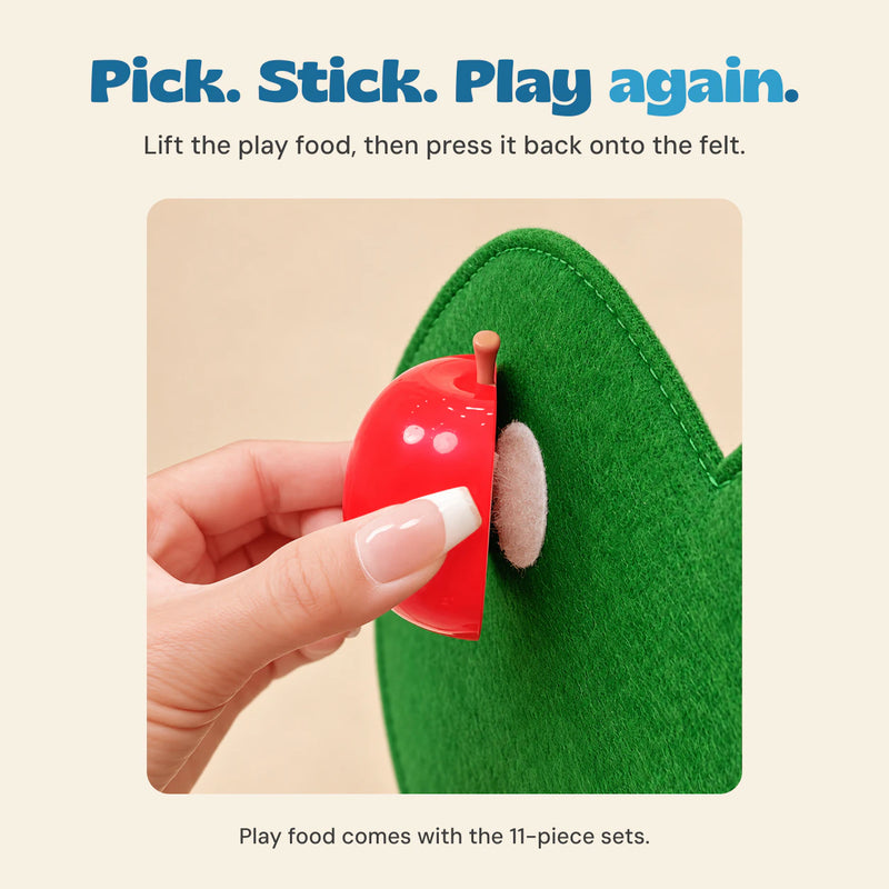 Close-up of a hand lifting the toy apple from the felt attachment patch.