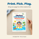 Adult hand holding a pencil beside a printed example of the original Little Swimmers Activity Pack cover on a quiet table.