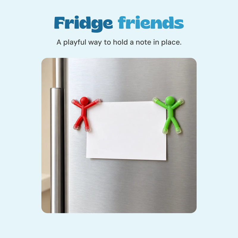 Red and green magnetic figures holding a blank note on a refrigerator.