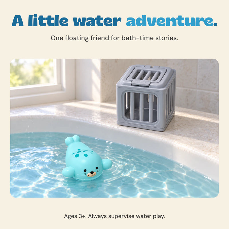 One turquoise seal toy floats in bath water while its gray rescue cage rests on the rim. Ages 3+. Adult supervision required for water play.