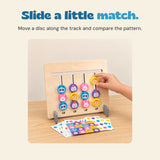 An existing hand moves the yellow monkey disc in the rightmost track of the actual animal matching board.