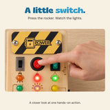 An adult finger presses the red rocker switch beside the coloured lights, shown in a close view of the upper board.