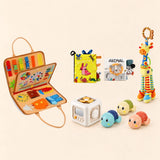 Animal Orange busy board with a busy cube, Garden Fun cloth book, Animal lion soft book, giraffe rattle and three turtle bath toys on a pale beige background.