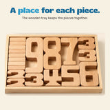 Close view of natural wooden numbers arranged inside their rectangular wooden storage tray.