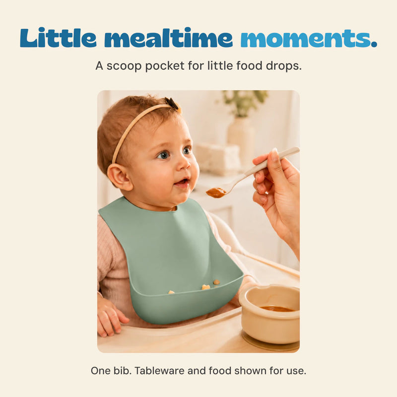 Original photograph of a child wearing the sage bib at mealtime, with small food pieces in the catch pocket.