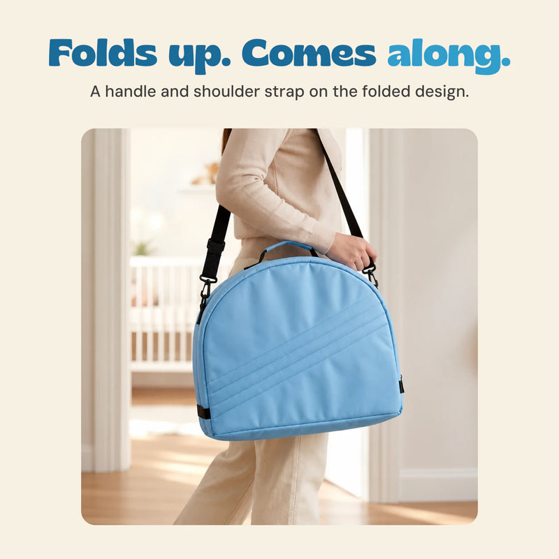 A cropped adult carries the folded blue tent by its black shoulder strap, with the top handle visible.
