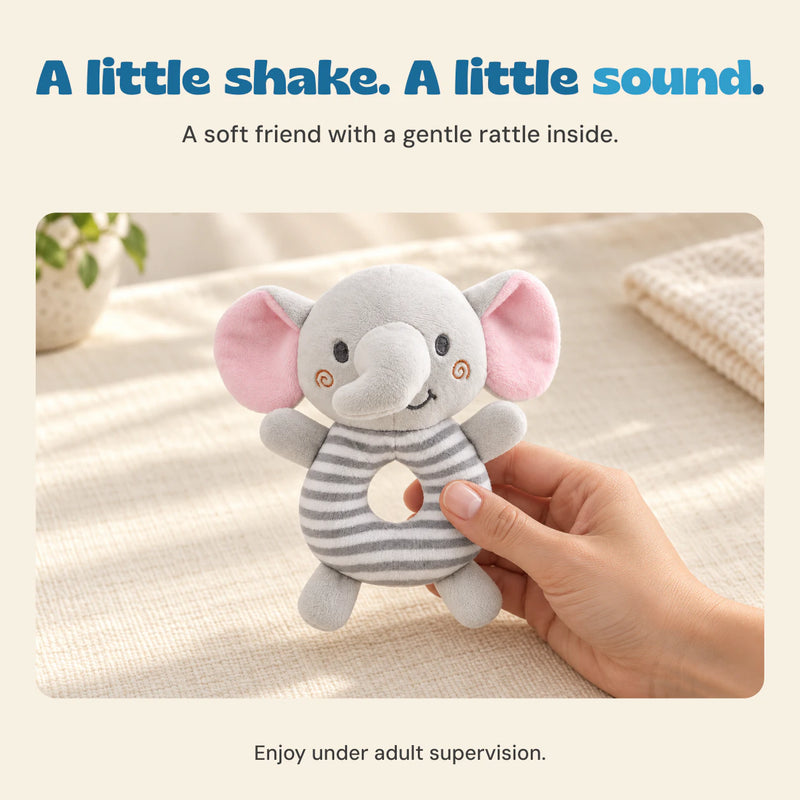 A hand holds the soft grey elephant rattle by its striped ring body.