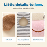 Close views of soft plush fabric, the ring-shaped body and a stitched smile on rattle friends.