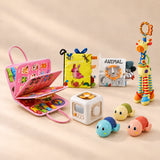 No-Screen Starter Kit Bundle with pink activity board, sensory books, giraffe, busy cube and three turtles in a warm beige studio