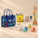 No-Screen Starter Kit Bundle with its matching busy board, cloth books, busy cube, giraffe rattle and three turtle toys on a warm beige studio surface.