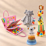 Mermaid Pink Plus busy board with an elephant comforter, giraffe rattle and six-ring koala stacking tower on a warm beige studio floor.