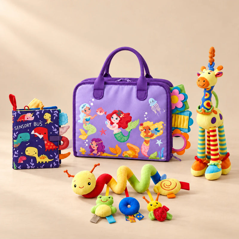 Sensory Explorer Bundle with a purple mermaid busy board, dinosaur cloth book, giraffe rattle and spiral stroller toy on a warm beige studio floor.