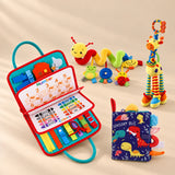 Sensory Explorer Bundle with a rocket green busy board, dinosaur cloth book, giraffe rattle and spiral stroller toy on a warm beige studio floor.