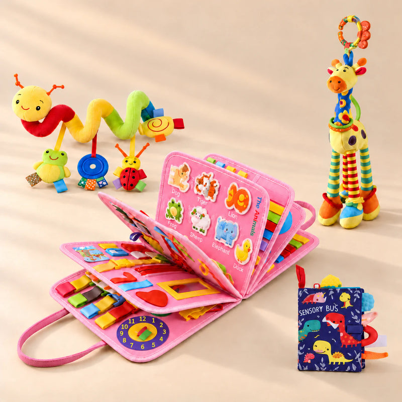 Mermaid Pink Plus busy board with a dinosaur sensory book, giraffe rattle and spiral toy on a warm beige studio floor.