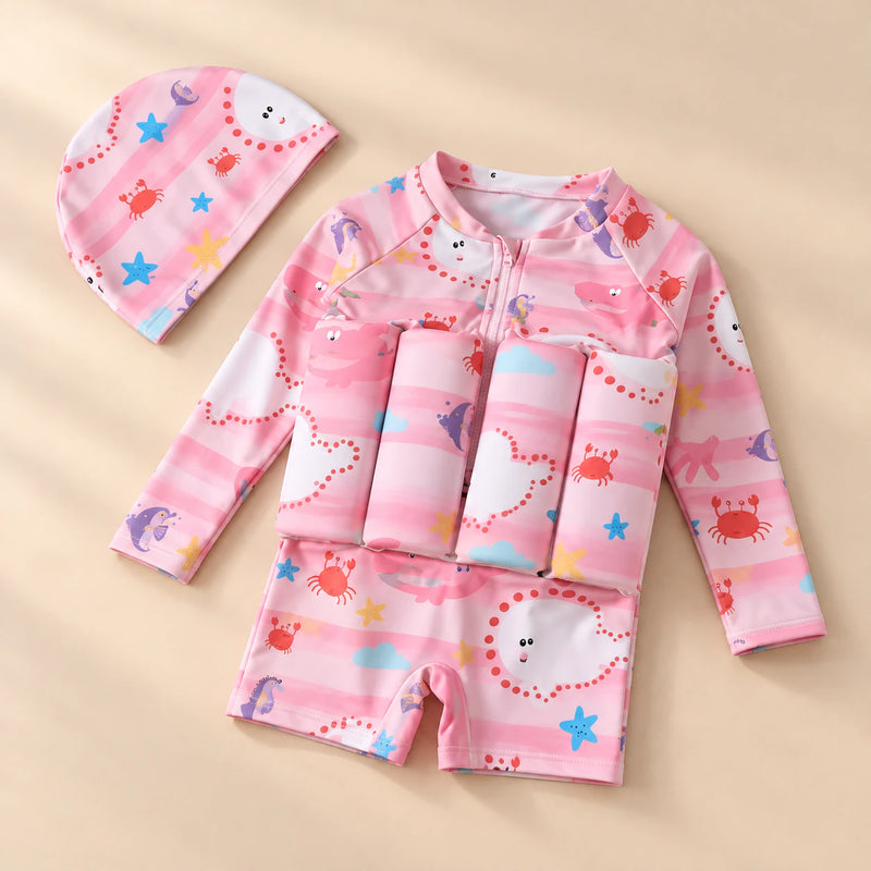 TibaToes™ FloatPal Kids Buoyancy Swimsuit photographed with its matching design and colours on a warm beige studio surface.