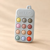Click & Calm Silicone Phone Teether on a warm beige studio background in Misty Grey