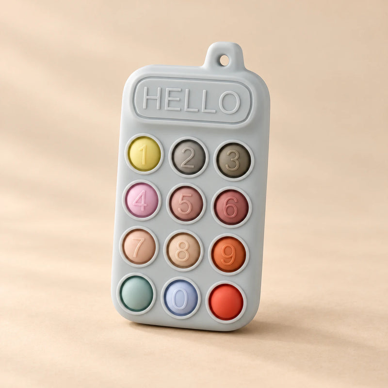 Click & Calm Silicone Phone Teether on a warm beige studio background in Misty Grey