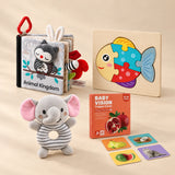 Little Learner Bundle with Animal Kingdom cloth book, fish puzzle, elephant rattle and high-contrast cards on a beige studio surface.