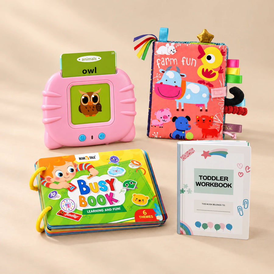 First Words Bundle with its matching toys and books arranged together on a softly lit warm beige studio surface.