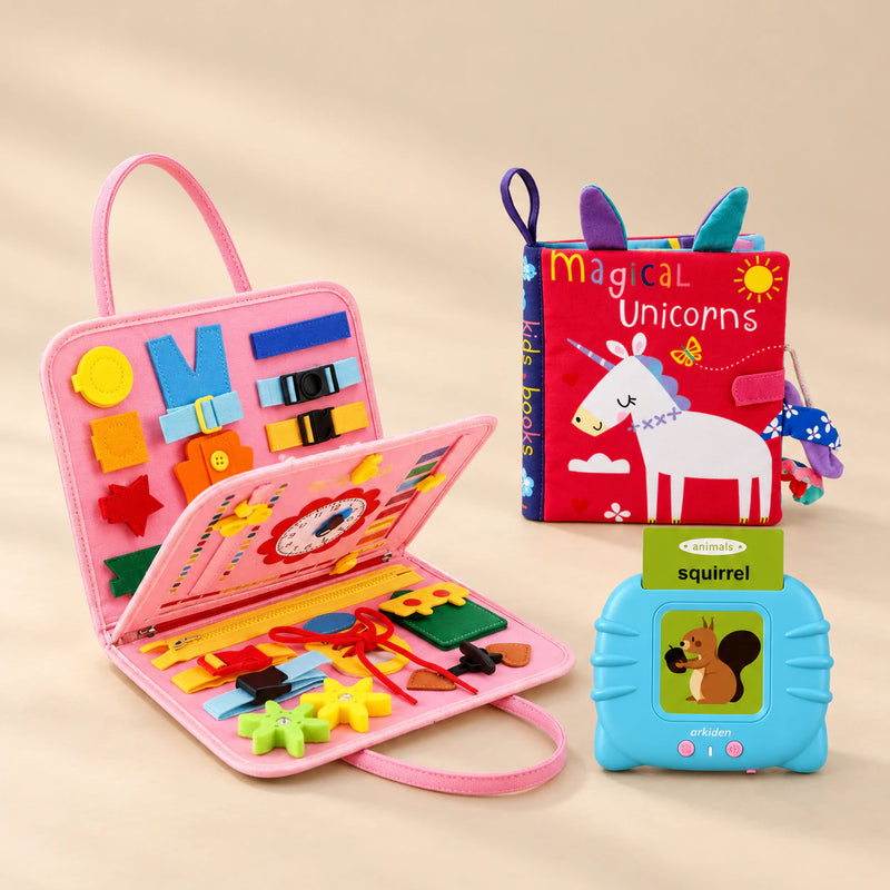 Grandparent Gift Bundle with a mermaid pink busy board, blue talking flashcard reader and Magical Unicorns sensory book on a beige studio surface.