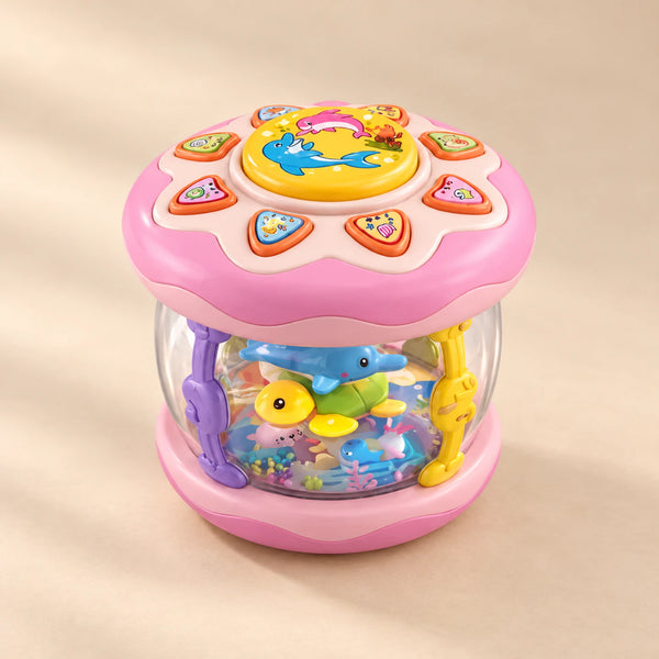 Pink Crawl and Glow musical rolling toy with a transparent ocean scene, photographed on a warm beige studio surface.