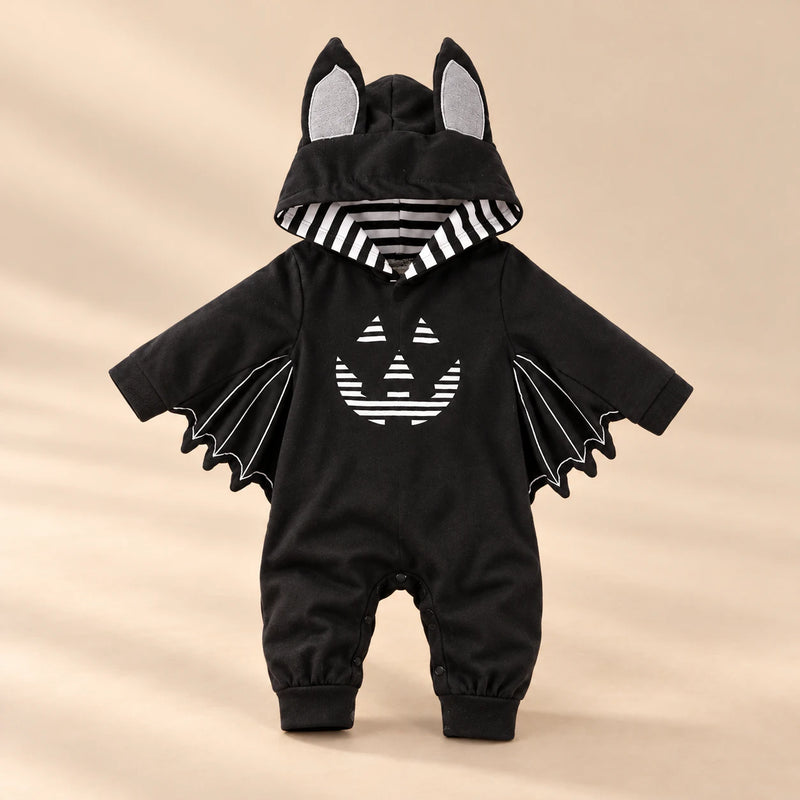 Little Bat Hooded Romper on a warm beige studio background in Pumpkin Bat Romper