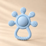 LittleGrip Silicone Teether Rattle on a warm beige studio background in Sky Blue Teether