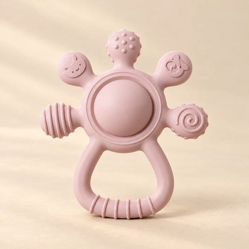 LittleGrip Silicone Teether Rattle on a warm beige studio background in Blush Pink Teether