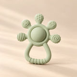 LittleGrip Silicone Teether Rattle on a warm beige studio background in Sage Green Teether