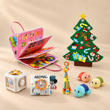 Christmas Wonder Learning Bundle with the Mermaid Pink Plus busy board, arranged on a warm beige studio surface.