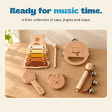 The five-instrument wood bear music set and mallet arranged on an oak table in soft natural light.