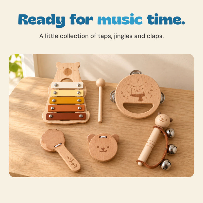 The five-instrument wood bear music set and mallet arranged on an oak table in soft natural light.