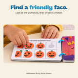 Original child hands matching the Halloween Busy Book pumpkin face pieces beside its printed cover.