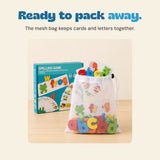 White mesh drawstring pouch holds the real spelling cards and colourful letters, beside the teal game box.
