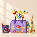 Mermaid Purple Plus Sensory Explorer Bundle with its busy board, dinosaur soft book, giraffe toy and hanging spiral toy on a warm beige background.