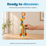 An adult hand holds the included giraffe toy above a wooden table in a warm naturally lit room.