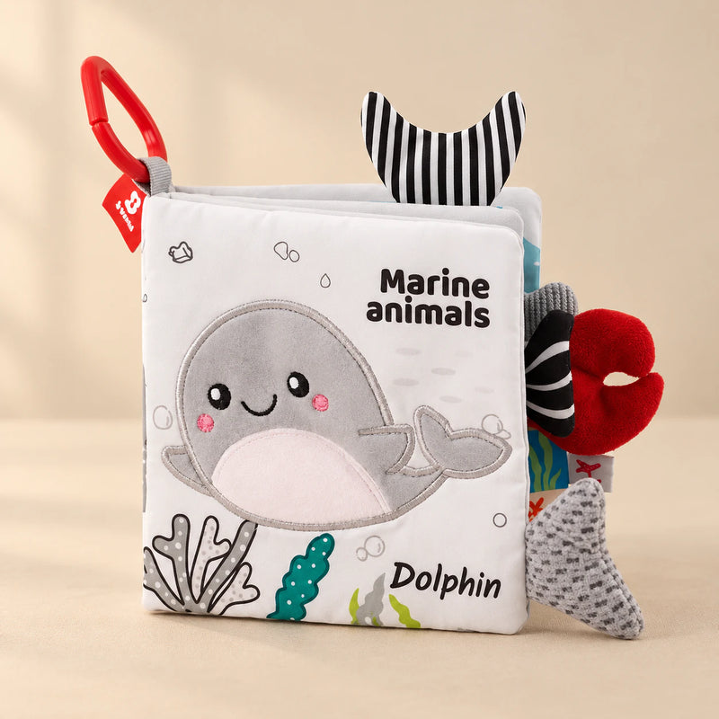 Marine Animals sensory cloth book with a plush dolphin, red clip and fabric tails.