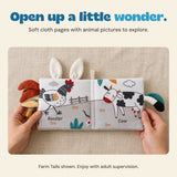 Hands hold the Farm Tails cloth book open to its rooster and cow pages.