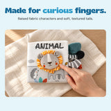 A hand touches the striped fabric mane on the Animal cloth book.