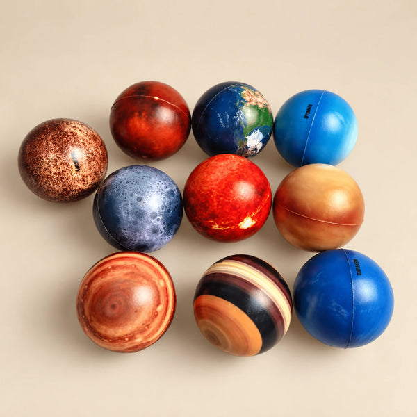 Ten planet-themed balls with eight planets, the Moon and a standard Sun on a warm beige studio background.