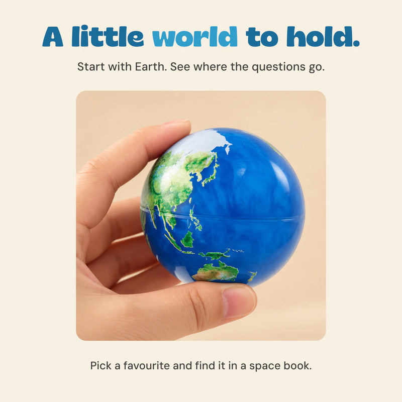 An adult hand holding the Earth ball, with an idea to find the matching planet in a space book.