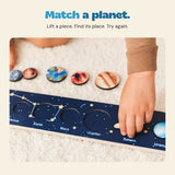 A child placing the Saturn piece into the solar system puzzle strip.