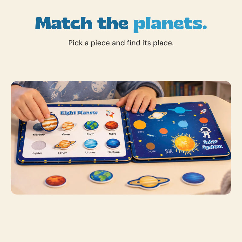 Hands match removable planet pieces to an open Space quiet book, with more planet pieces on the table.