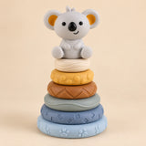 Koala stacking tower with six textured rings in pale blue, slate blue, sage, brown, yellow and ivory.