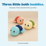 Three colourful wind-up turtles included together, shown on a smooth beige studio surface.