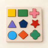 Nine colourful wooden shapes in their matching recesses on a natural wood board.